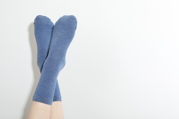 Woman in blue socks on light background, closeup. Space for text