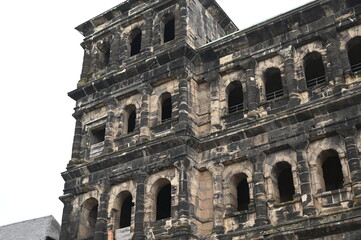 Obraz premium Historic Roman city gate Porta Nigra in Trier, Germany — ancient stone architecture with arched windows and aged facade. UNESCO World Heritage landmark and iconic tourist attraction. Ideal for travel 