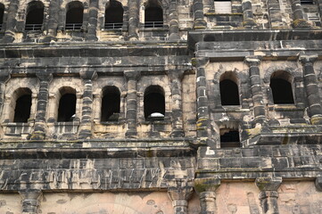 Naklejka premium Historic Roman city gate Porta Nigra in Trier, Germany — ancient stone architecture with arched windows and aged facade. UNESCO World Heritage landmark and iconic tourist attraction. Ideal for travel 