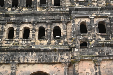 Naklejka premium Historic Roman city gate Porta Nigra in Trier, Germany — ancient stone architecture with arched windows and aged facade. UNESCO World Heritage landmark and iconic tourist attraction. Ideal for travel 
