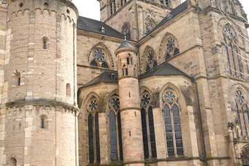 Obraz premium Gothic cathedral facade with tall stained glass windows and stone architecture. Historical European church building, detail of wall and arches. Travel and heritage concept.