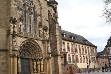 Fototapeta premium Gothic cathedral facade with tall stained glass windows and stone architecture. Historical European church building, detail of wall and arches. Travel and heritage concept.