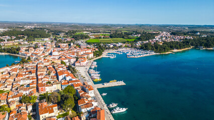 Obraz premium Aerial view of Poreč (Porec), Croatia, showcasing the charming old town, vibrant coastline, and the nearby island of Sveti Nikola. The stunning Zelena Laguna area adds to the beauty turquoise waters