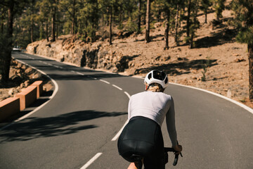 Female cyclist rides along a scenic mountain road.  Stunning views and a sense of freedom. Perfect...