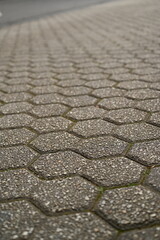 Obraz premium pentagonal grey paving tile texture, grey tile pattern as background, grey tile texture close up tiles as a background in the old town, grey tiles
