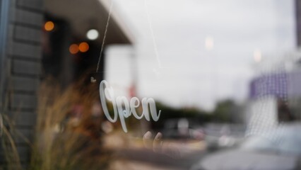 Employee opening coffee shop by flipping sign board on door, small business startup