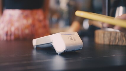 Close-up of customer paying with smartphone, digital cashless transaction in cafe