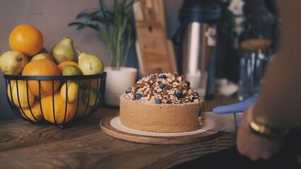 Coffee shop worker cutting slice of cake in cafeteria, dessert service in small business