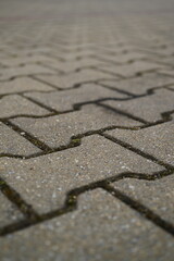 Gray concrete paving blocks arranged in zigzag patterGray concrete paving blocks arranged in zigzag pattern. Textured stone pn. Textured stone pavement for urban road, parking lot, or sidewalk design.