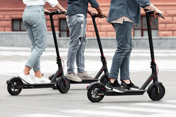 Active Lifestyle. Cropped view of three multiracial millennials driving electric kick scooters in...