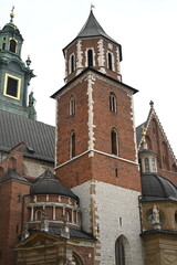 Historic brick building with a small balcony, traditional windows, and architectural details. The warm red brick facade and classic design elements create a vintage European atmosphere.