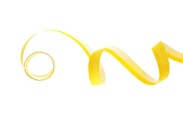Fototapeta premium Yellow serpentine streamer on white background. Festive decor