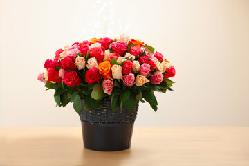 Beautiful bouquet of colorful roses on wooden table
