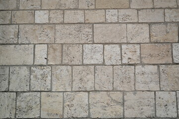 grey stone pavement with rectangular cobblestones in light gray and beige tones. Geometric street texture background