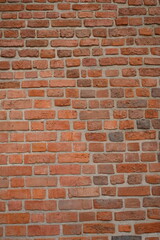 Fototapeta premium Red brick wall close up background. Vintage masonry texture of red bricks with mortar