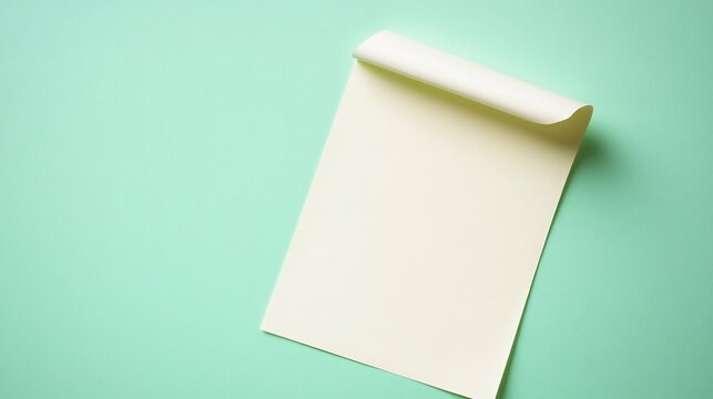 Blank sticky note with a curled corner resting on a pastel green background for a calm and professional vibe