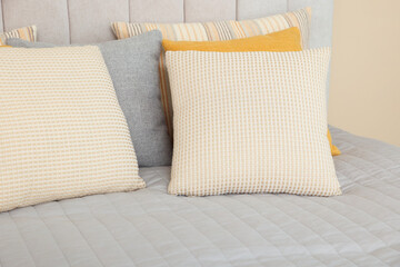Soft decorative pillows on bed in bedroom