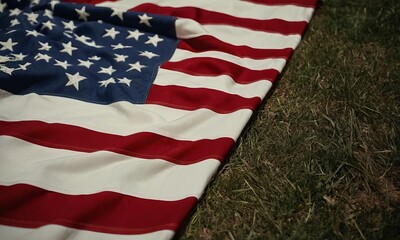 Obraz premium American Flag Resting on Grass Depicting Patriotism and National Pride