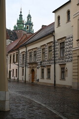 Historic European street with old buildings and church tower. Narrow cobblestone alley with traditional architecture, ideal for travel, tourism, and cultural heritage themes.