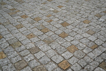 Gray cobblestone pavement with yellow accent stones. Natural stone texture with geometric pattern, perfect for architecture, design, and 3D visualization projects. Urban street background with aged su