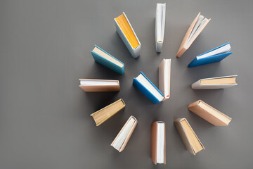 Clock made with books on grey background, flat lay. Space for text