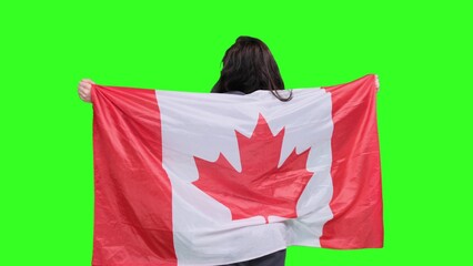 Happy woman draping Canadian flag over her shoulders on the chroma key