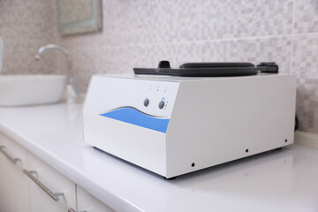 Routine centrifuge on white counter indoors, closeup