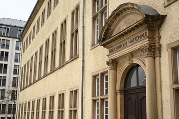 Fototapeta premium Historic government building entrance in Luxembourg City. Elegant stone doorway with columns and arched wooden door — example of European architecture and civic heritage.