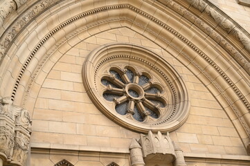 Gothic cathedral window detail in Luxembourg City. Stone arch with decorative rose window — historical European architecture and cultural heritage.