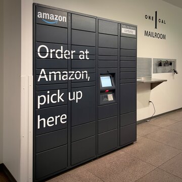 LOS ANGELES, CA, SEP 4, 2024: close view Amazon Hub Locker system in a building mailroom, Downtown. Black lockers with "Order at Amazon, pick up here" text and touchscreen interface