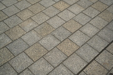 grey stone pavement with square tiles forming a geometric pattern