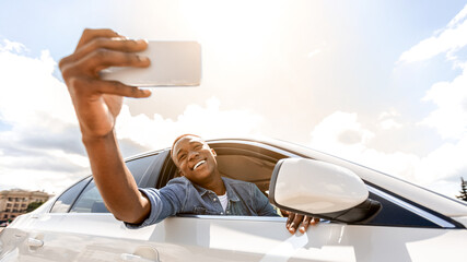 Emotional afro american guy taking selfie, shooting story for his friends and followers on social...