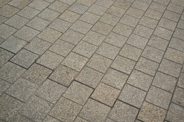 grey stone pavement with square tiles forming a geometric pattern