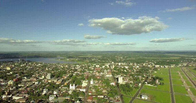 Aerial panorama of a city with green landscape and blue sky