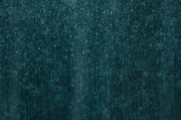 A dark teal abstract background featuring soft circular bokeh and subtle water droplet textures,...