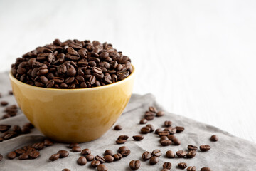 Organic Roasted Coffee Beans in a Bowl, side view. Copy space.