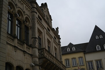 Historic European building facade with windows and mansard roof. Classic architecture and urban detail background, Luxembourg or Northern France style.
