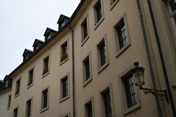 Historic European building facade with windows and mansard roof. Classic architecture and urban detail background, Luxembourg or Northern France style.