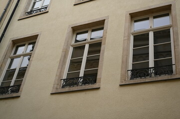 Historic European building facade with windows and mansard roof. Classic architecture and urban detail background, Luxembourg or Northern France style.