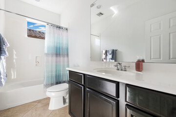 A bathroom that includes a sink, toilet, tub, and a mirror for use