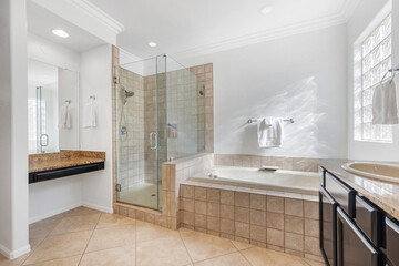 A bathroom that includes a tub, shower, sink, and a mirror above