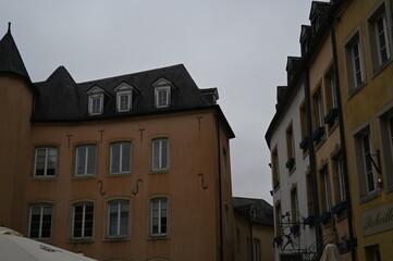 Narrow street with historic yellow buildings in Luxembourg City. Traditional European architecture with windows and tiled roofs — quiet atmosphere of the old town.