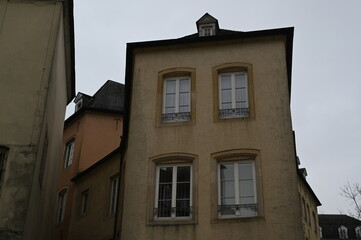 Narrow street with historic yellow buildings in Luxembourg City. Traditional European architecture with windows and tiled roofs — quiet atmosphere of the old town.