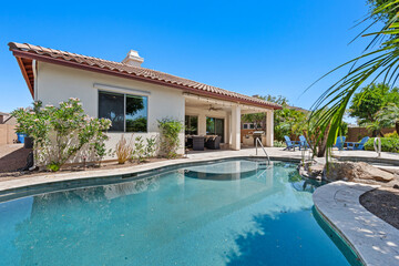 A beautiful house featuring a large swimming pool situated right in front of it