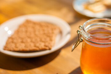 Honey Jar and Gingerbread Cookie on a Table, Warm Sunlight Creates a Cozy Cafe Vibe. Perfect for Bakeries
