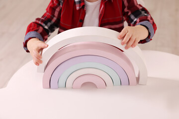 Motor skills development. Little boy playing with toys at white table indoors, closeup