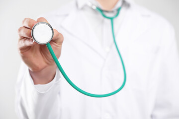Doctor with stethoscope on light background, closeup