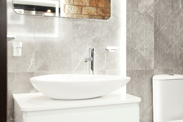 Stylish bathroom with vessel sink and vanity near tiled wall. Interior design