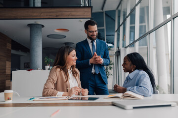 Manager explaining business strategy to employees in modern office