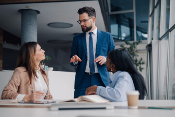 Manager explaining business strategy to colleagues in office meeting